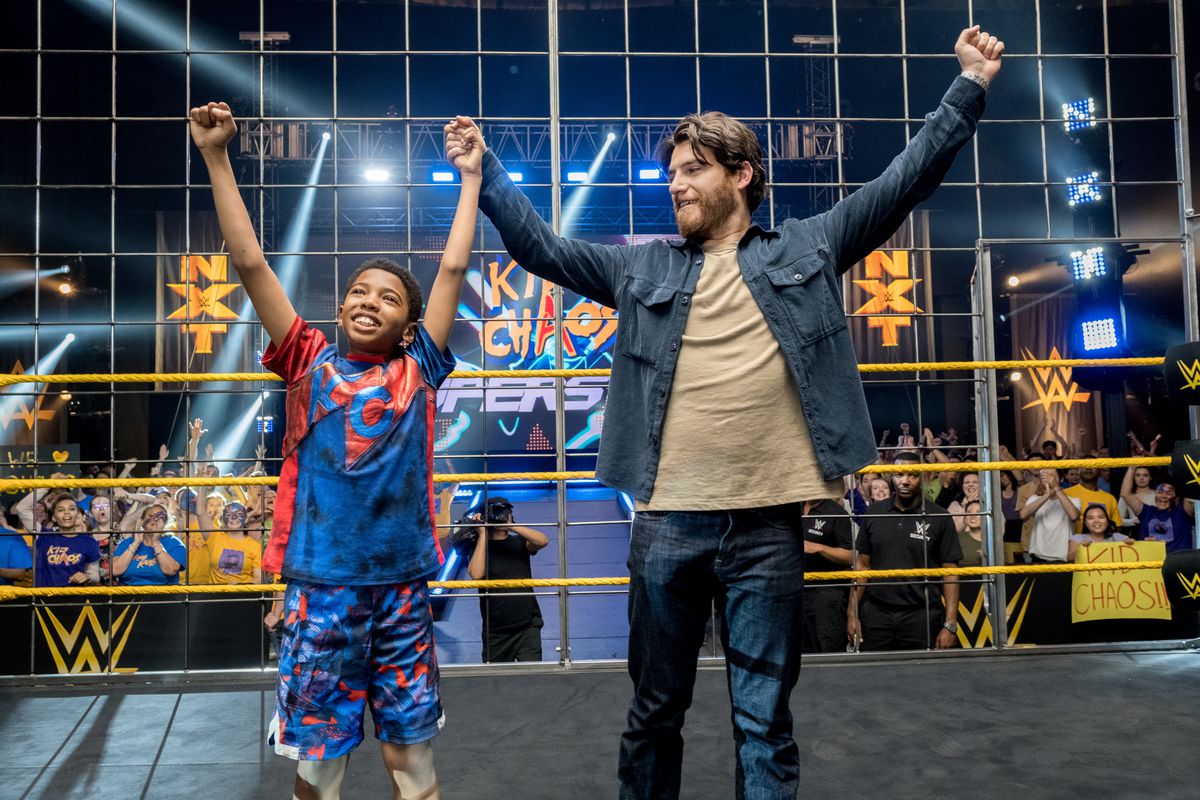 Leo alza le mani trionfante sul ring con suo padre nel Main Event