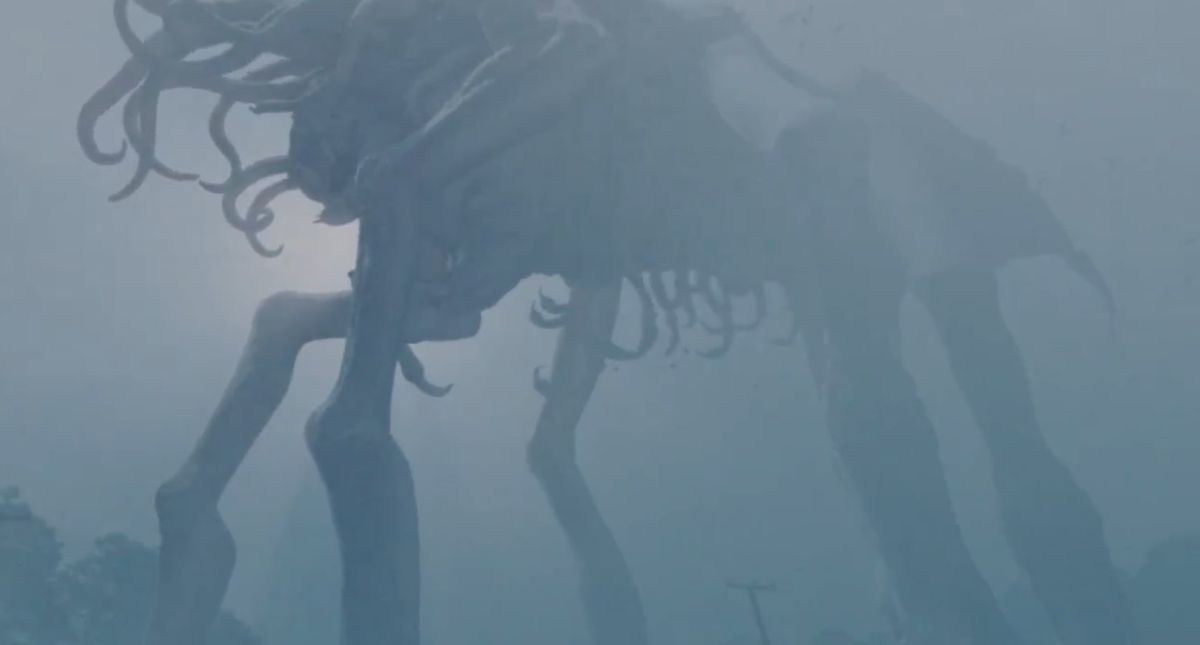 Una gigantesca creatura a più zampe con viticci che si contorcono che si aggira pesantemente attraverso un paesaggio coperto di nebbia.