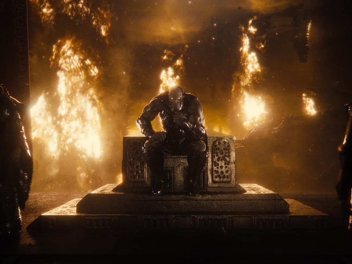Il cattivo alieno Darkseid siede su un trono in una stanza in fiamme nella Justice League di Zack Snyder