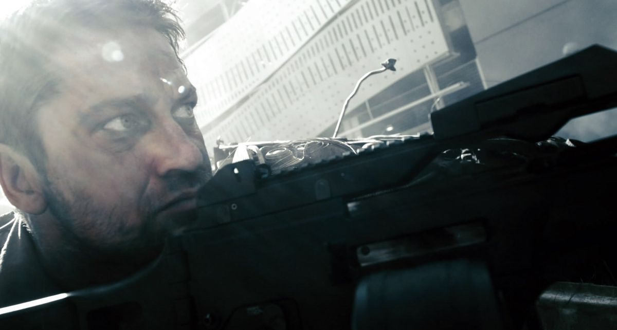 Gerard Butler in Gamer accovacciato con una mitragliatrice