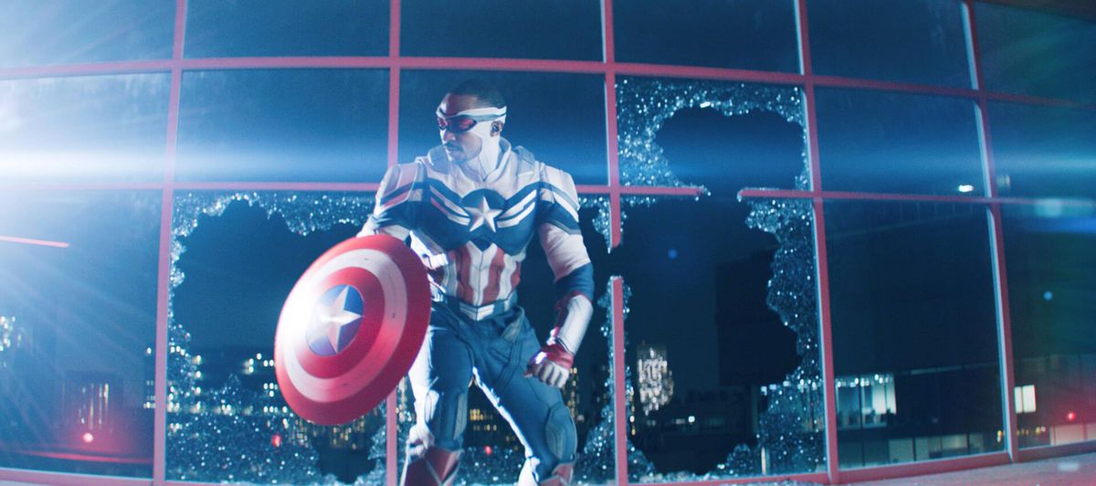 Anthony Mackie nei panni del nuovo Capitan America si accovaccia davanti ad alcune finestre in frantumi