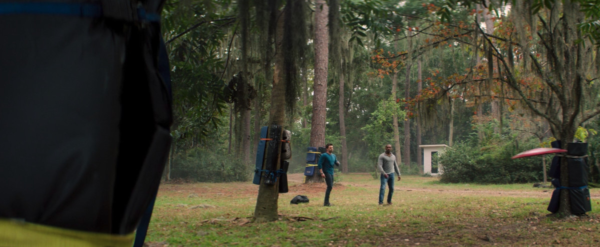 Anthony Mackie e Sebastian Stan frisbee lo scudo di Capitan America intorno, circondati da alberi imbottiti