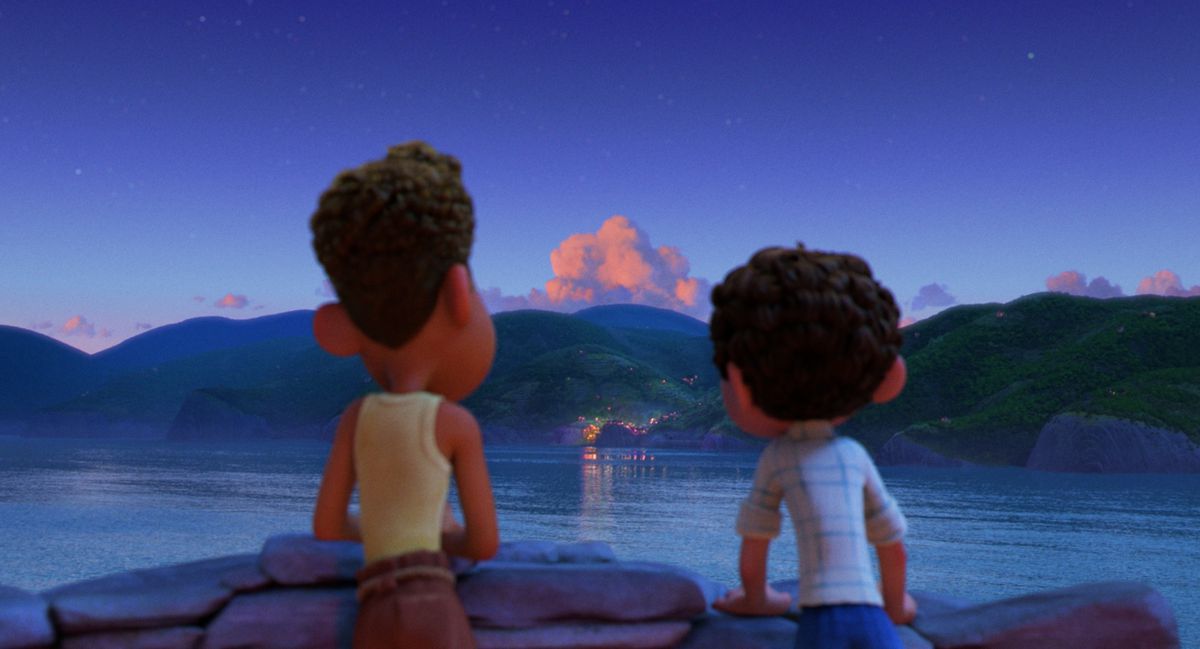 Luca e Alberto guardano di sera un paese al di là dell'acqua