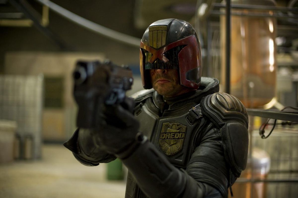 Karl Urban (Dredd) punta la sua pistola in Dredd di Pete Travis (2012)
