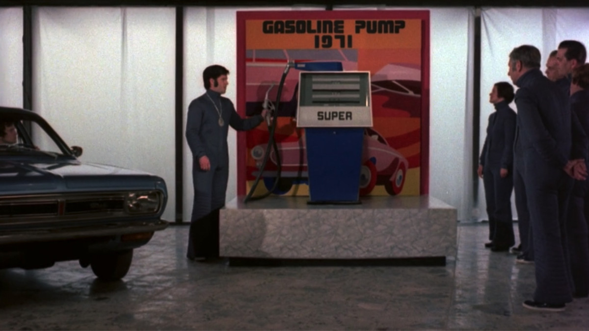 A group of men in a 20th-century museum in ZPG try out a 1970s-style gas pump