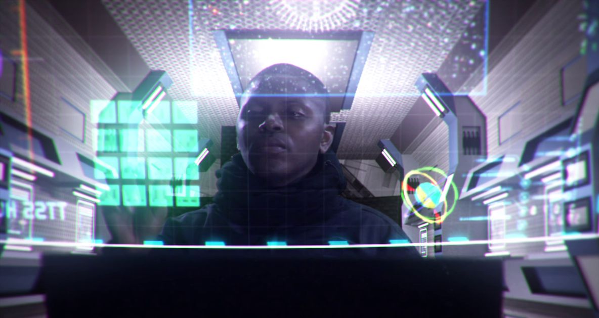 Un uomo nero siede dietro un pannello di controllo con più luci olografiche nella Tomba