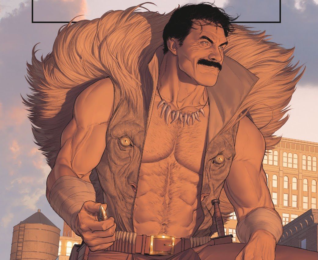 Kraven the Hunter è in piedi su un tetto, sorridendo leggermente, tenendo un grosso proiettile in mano, nel suo giubbotto aperto coronato da una criniera di leone.  I suoi muscoli e peli sul petto sono resi amorevolmente, in Might Valkyries # 2, Marvel Comics (2021). 