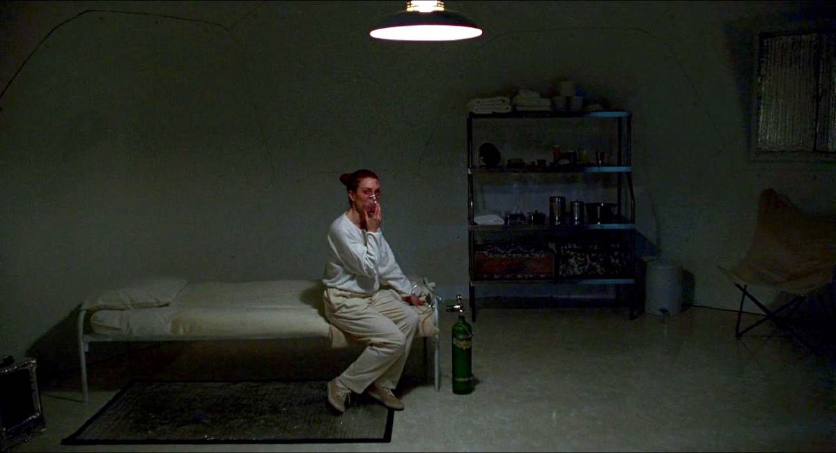Julianne Moore come Carol White respira in una maschera di ossigeno mentre è seduta su un lettino in una grande cupola aperta in Safe (1995)