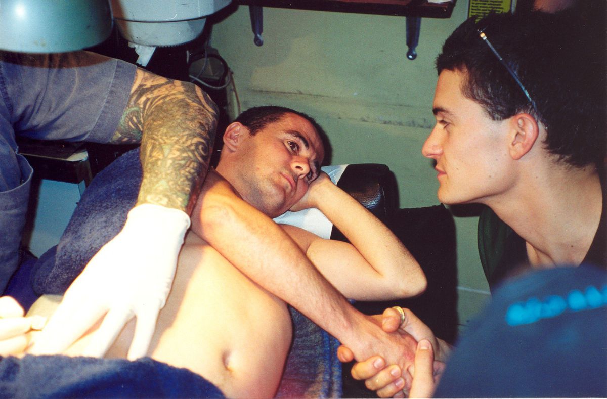 Orlando Bloom tiene la mano di Brett Beattie mentre quest'ultimo è tatuato.