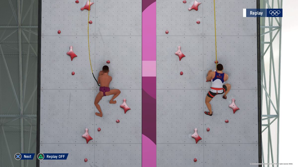 uno scalatore scala un muro di gara indossando la cintura di un lottatore di sumo ai Giochi Olimpici di Tokyo 2020