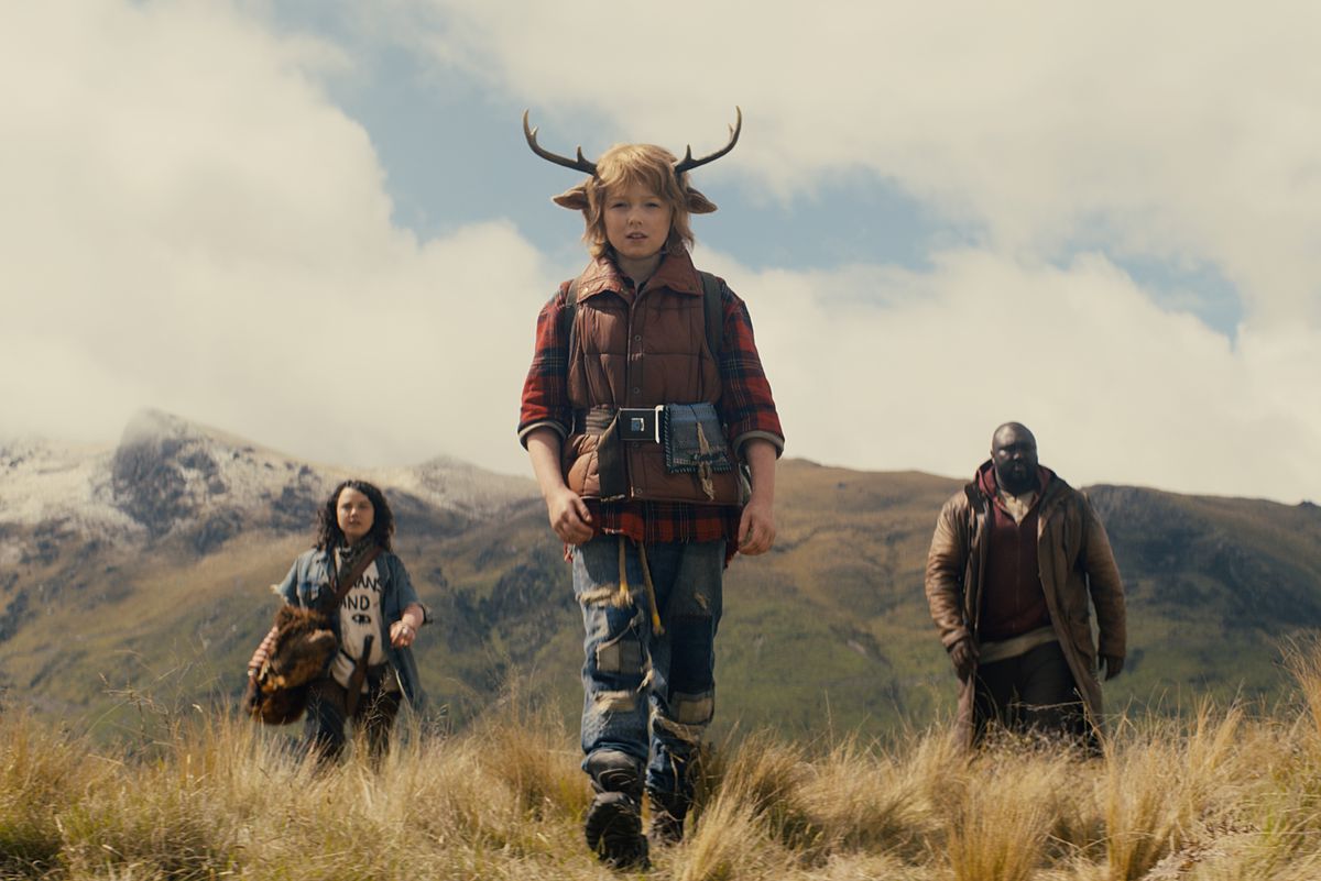 Il ragazzo dei cervi Gus (Christian Convery) cammina davanti ai suoi alleati adulti di fronte alle montagne nella prima stagione di Sweet Tooth di Netflix.