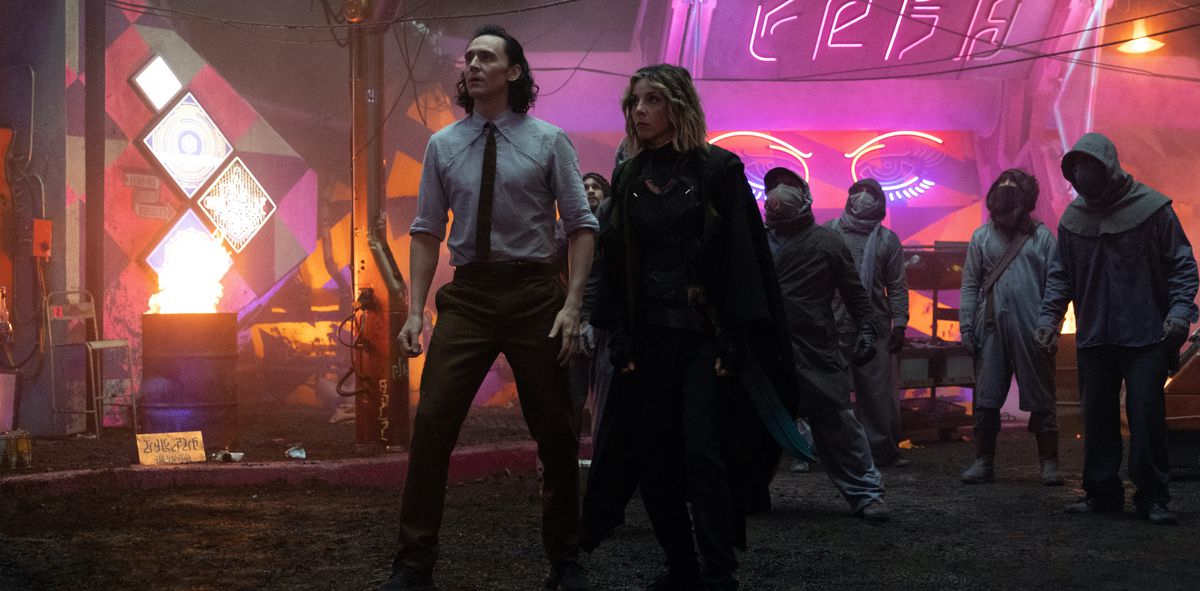 Loki and Sylvie (Tom Hiddleston and Sophia Di Martino) stride through the disintegrating neon city on Lamentis-1 in episode 3 of Loki