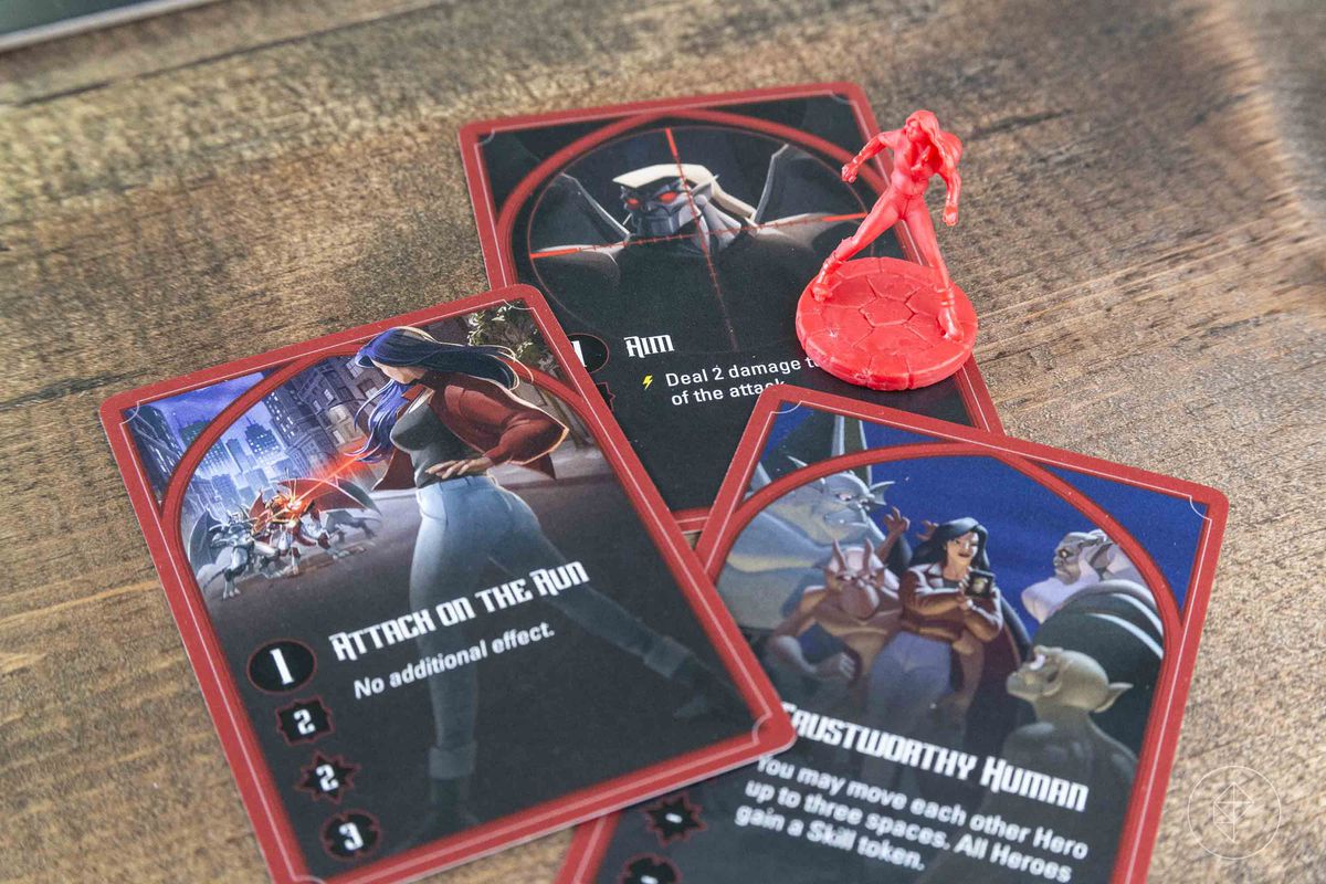 Un personaggio rosso con una collezione delle sue carte, che la mostra mentre prende la mira e spara con una pistola.