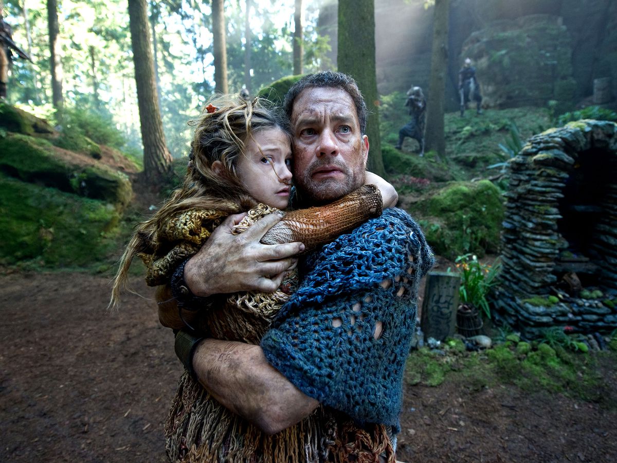 Zachry (Tom Hanks) stringe a sé un bambino mentre è circondato da predoni in Cloud Atlas.
