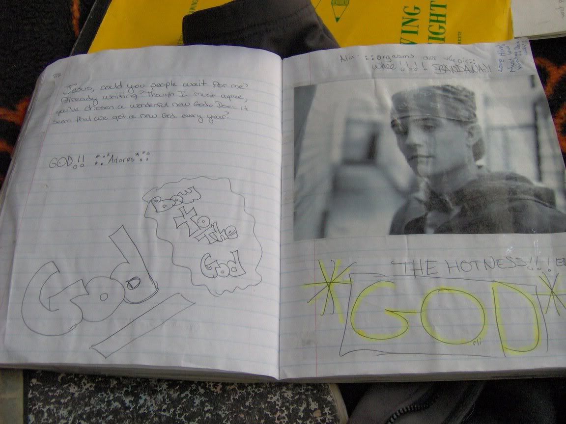 A lined notebook, with a black and white picture of Orlando Bloom wearing a hooded sweatshirt and a bandanna. “THE HOTNESS!!! *GOD*” is written below the photos in enormous letters and yellow highlighter. 