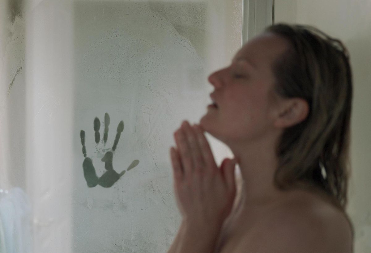 Elisabeth Moss sotto la doccia con una misteriosa impronta di mano sulla porta appannata in The Invisible Man