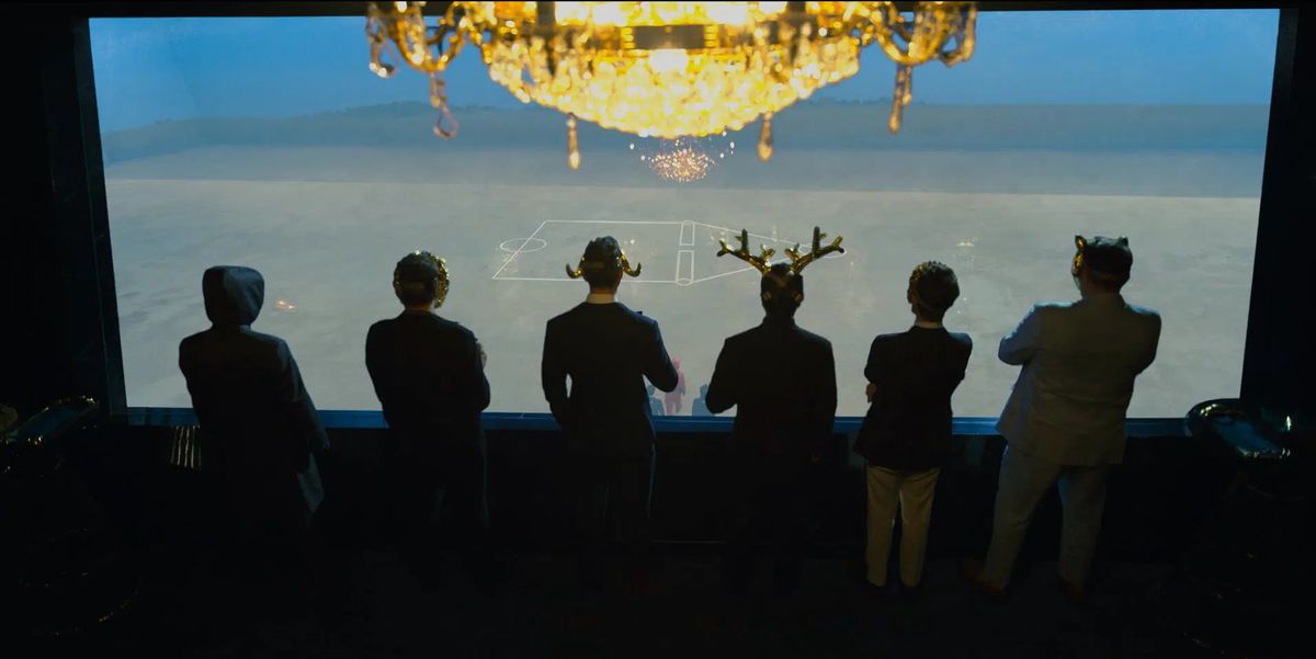 Un gruppo di sei uomini mascherati guarda il campo della partita finale di Squid Game.