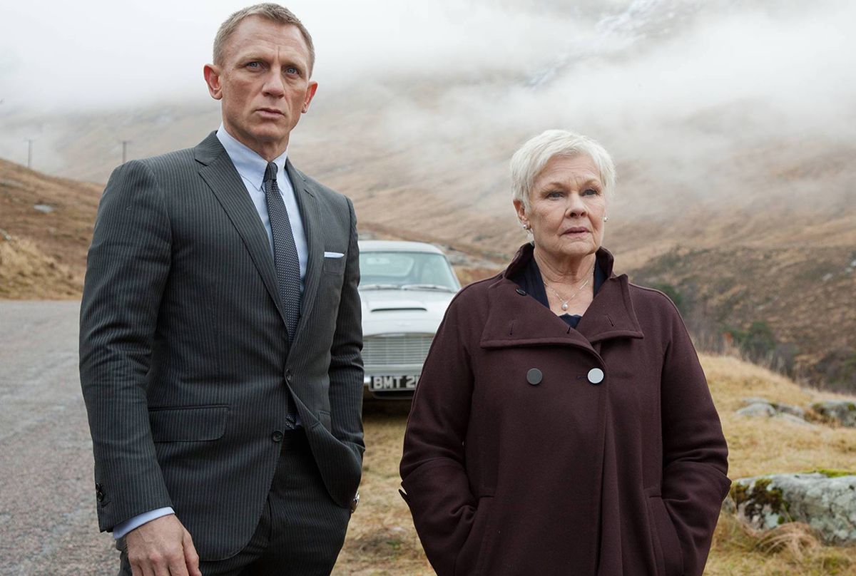 Bond e M stanno davanti a un'auto di lusso nella nebbiosa Scozia a Skyfall