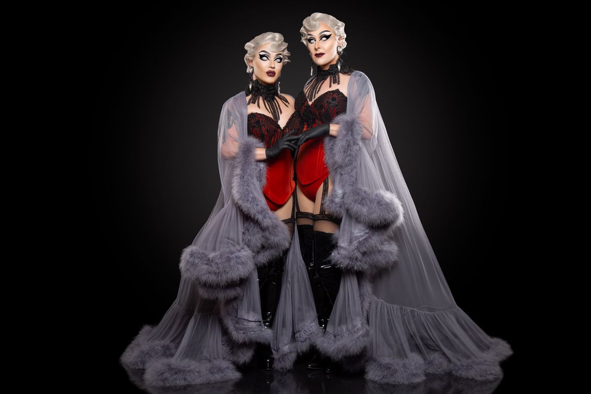 Dracmorda e Swanthula Boulet in lingerie rossa, grigio vaporoso, vestaglie di pelliccia, calze nere e parrucche corte impeccabilmente ondulate. 