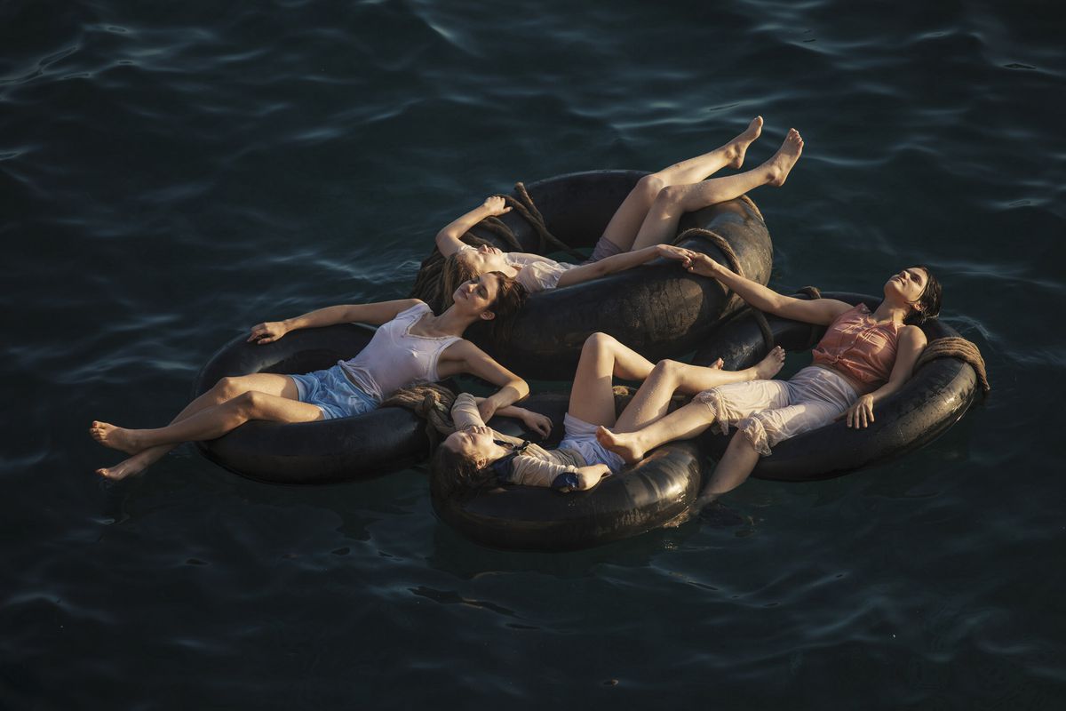 Le donne di Mayday si rilassano su camere d'aria galleggianti sull'oceano, tenendosi per mano per stare insieme