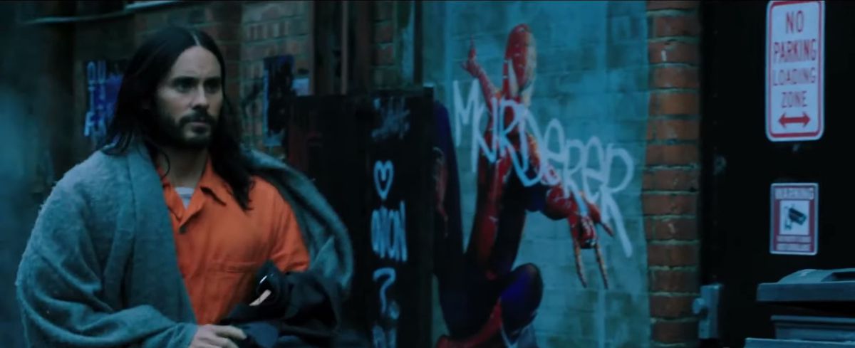 Morbius di Jared Leto cammina in un vicolo con un poster di Spider-Man sullo sfondo 