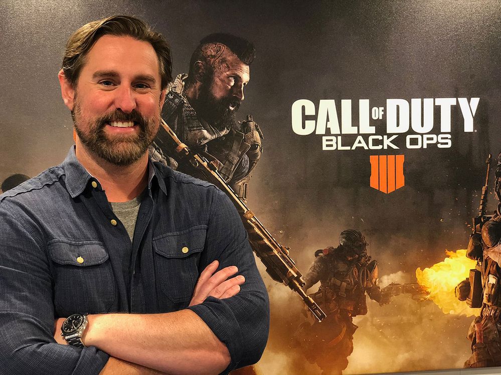 Una foto di Dan Bunting di Treyarch davanti all'artwork di Call of Duty: Black Ops 4