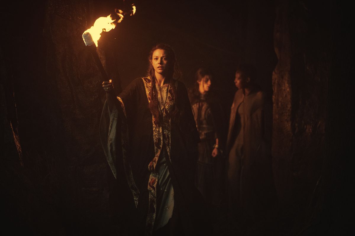 Due elfi guidano Yennefer di Vengerberg attraverso una grotta alla luce delle torce in The Witcher di Netflix