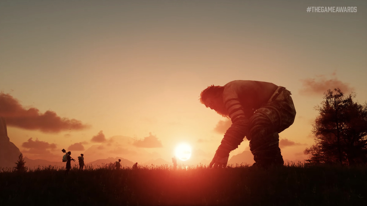 un gigante si accuccia mentre il sole tramonta in lontananza