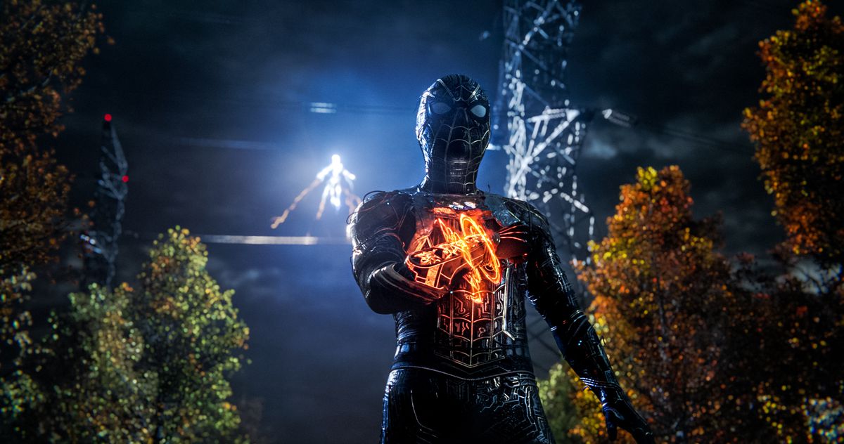 Spider-Man, in un abito nero con un dispositivo mistico al polso, si trova in un bosco oscuro mentre Electro appare sullo sfondo in Spider-Man: No Way Home.