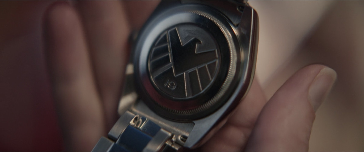 Il retro di un orologio porta un emblema SHIELD e il numero 19 in Occhio di Falco. 