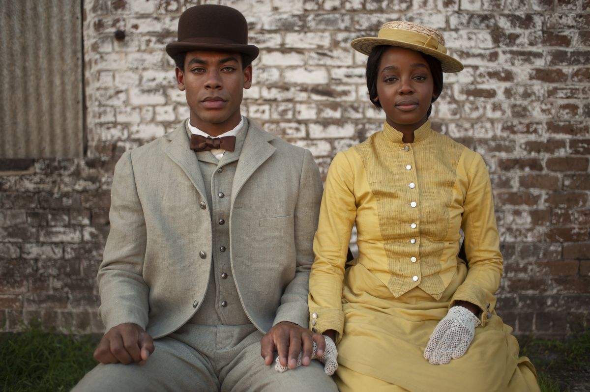 Two people sitting and looking at the camera in a still from The Underground Railroad 