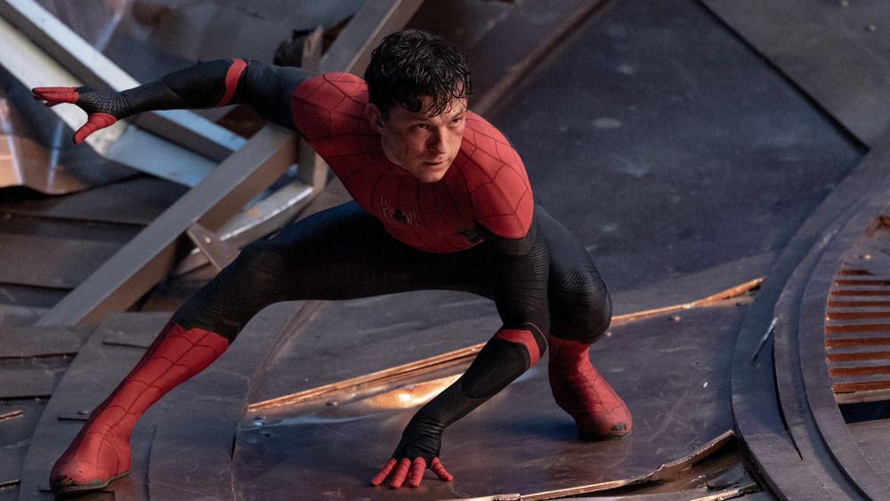 Peter Parker, smascherato nel suo costume da Spider-Man nero e rosso, si accuccia mentre si prepara a entrare in azione in Spider-Man: No Way Home