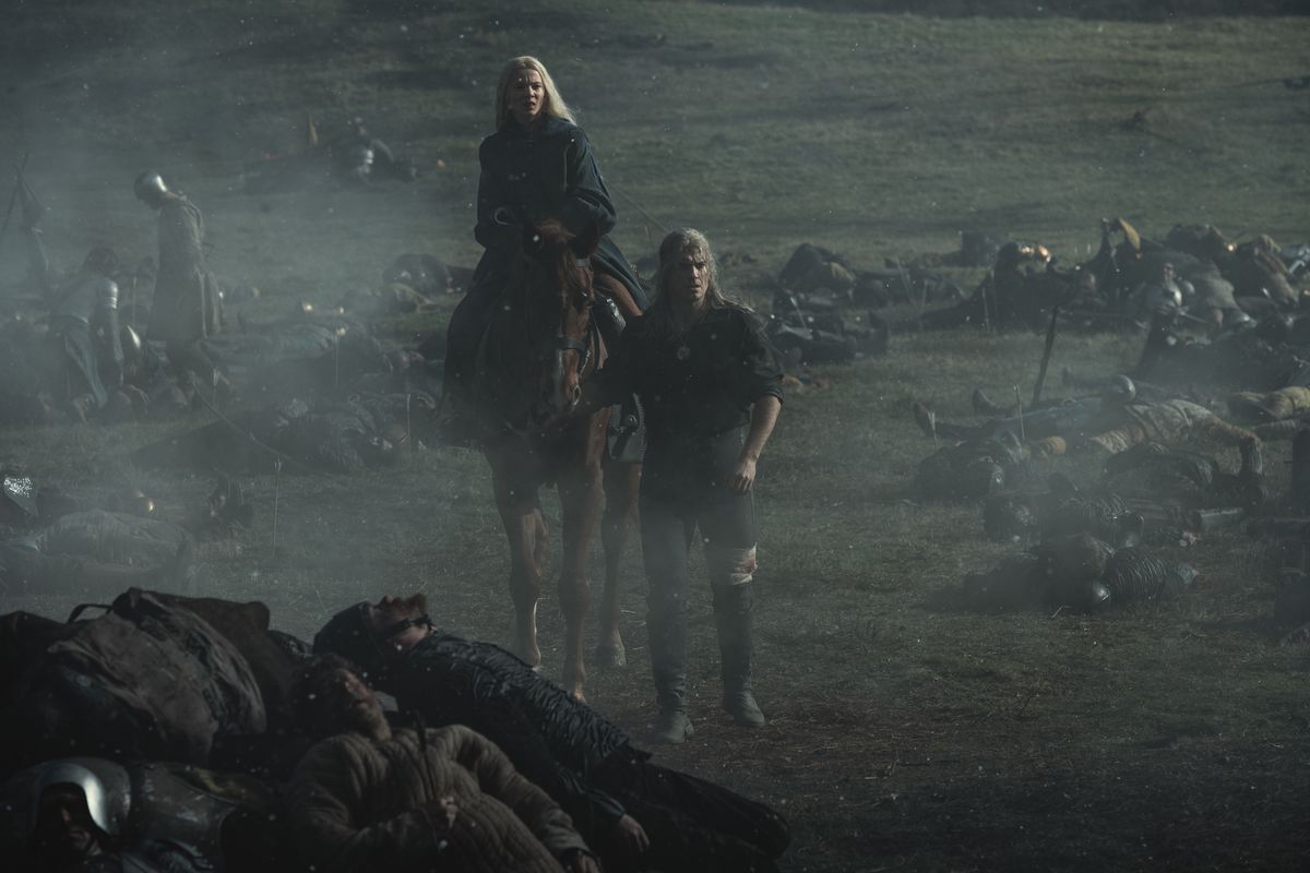 Geralt guida il suo cavallo a piedi mentre Ciri attraversa un campo di battaglia in The Witcher di Netflix