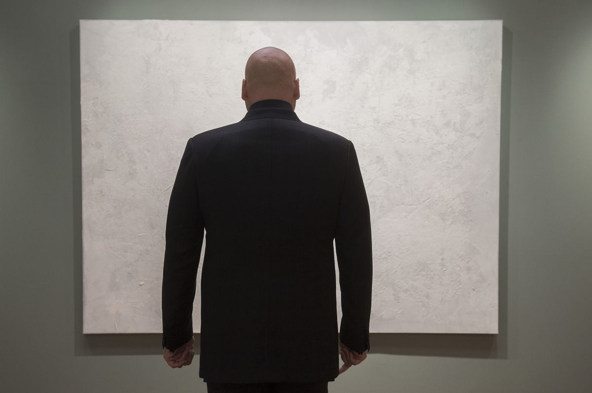 Vincent D'Onofrio nei panni di Wilson Fisk si trova di fronte a un dipinto astratto bianco in Daredevil. 