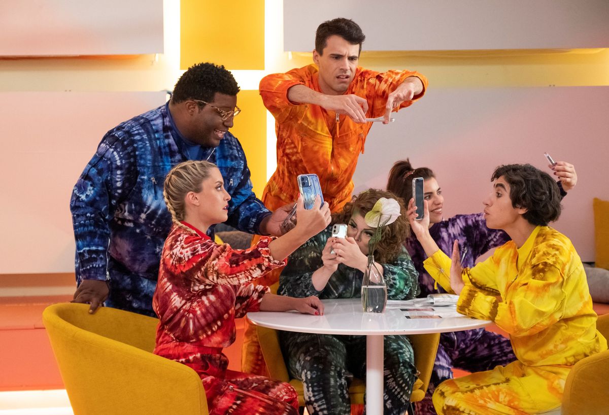 Gli influencer del culto di Dory si siedono intorno a un tavolo in tute dai colori vivaci nella quinta stagione di Search Party