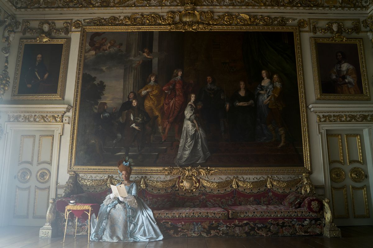 la regina d'Inghilterra seduta davanti a un enorme dipinto 
