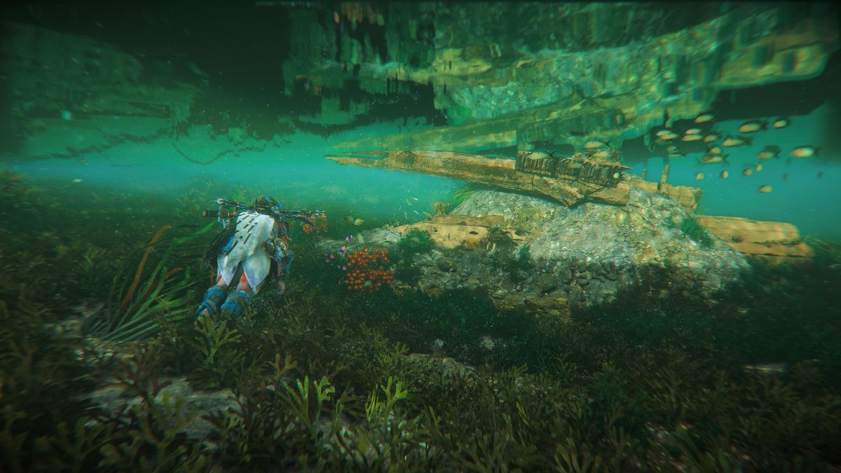 Aloy sta nuotando lontano dallo spettatore e l'immagine è incorniciata in modo tale che la superficie dell'acqua rifletta le strutture sott'acqua