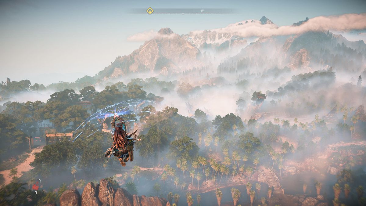 Aloy plana sopra una distesa nebbiosa di foresta con il suo Shieldwing in Horizon Forbidden West