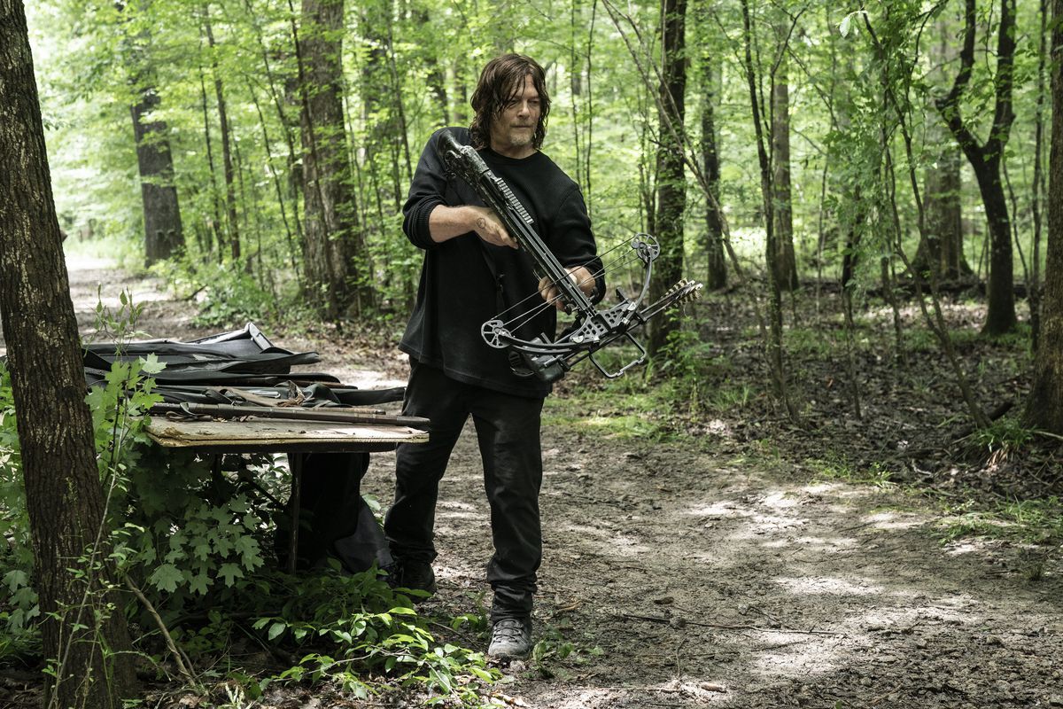 Daryl Dixon con in mano una pistola nel bosco