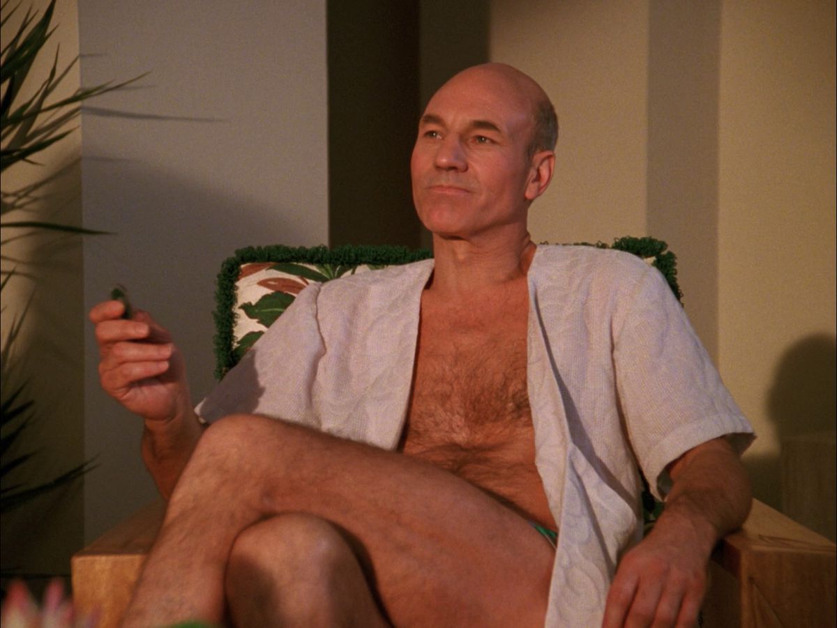 Picard sdraiato su una sedia con una camicia aperta