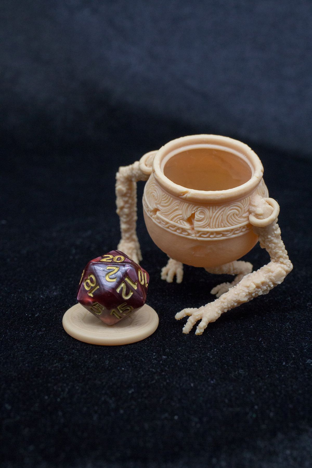 Un Pot Boy stampato in 3D di Elden Ring, con un dado sul coperchio del calderone
