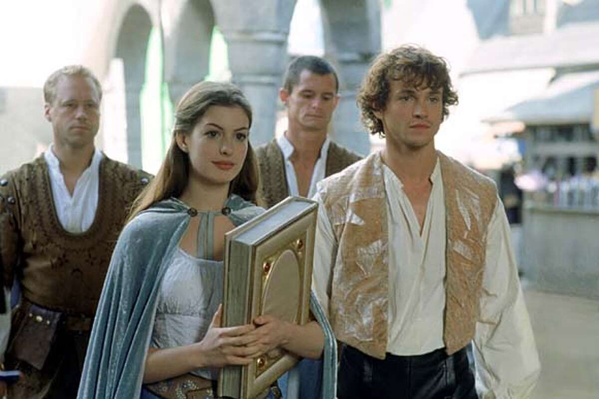 Ella (Anne Hathaway) tiene in mano un libro accanto al principe Charmont (Hugh Dancy) in Ella Enchanted.