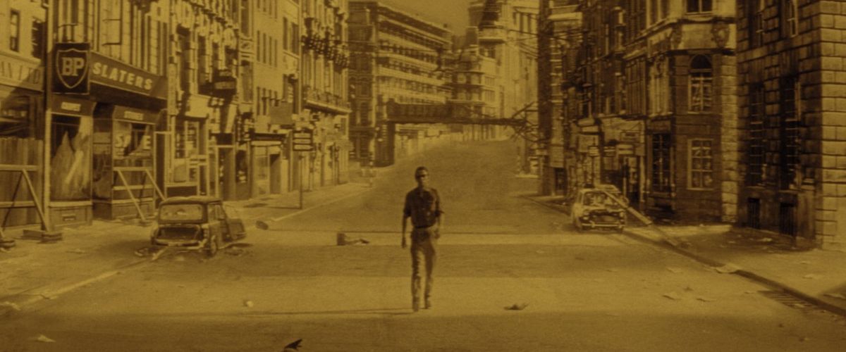 Un uomo solitario che cammina per una strada deserta della città nel giorno in cui la Terra ha preso fuoco.