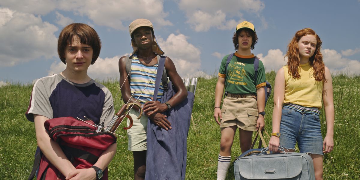 Will, Lucas, Dustin e Max in piedi in un campo in Stranger Things s3