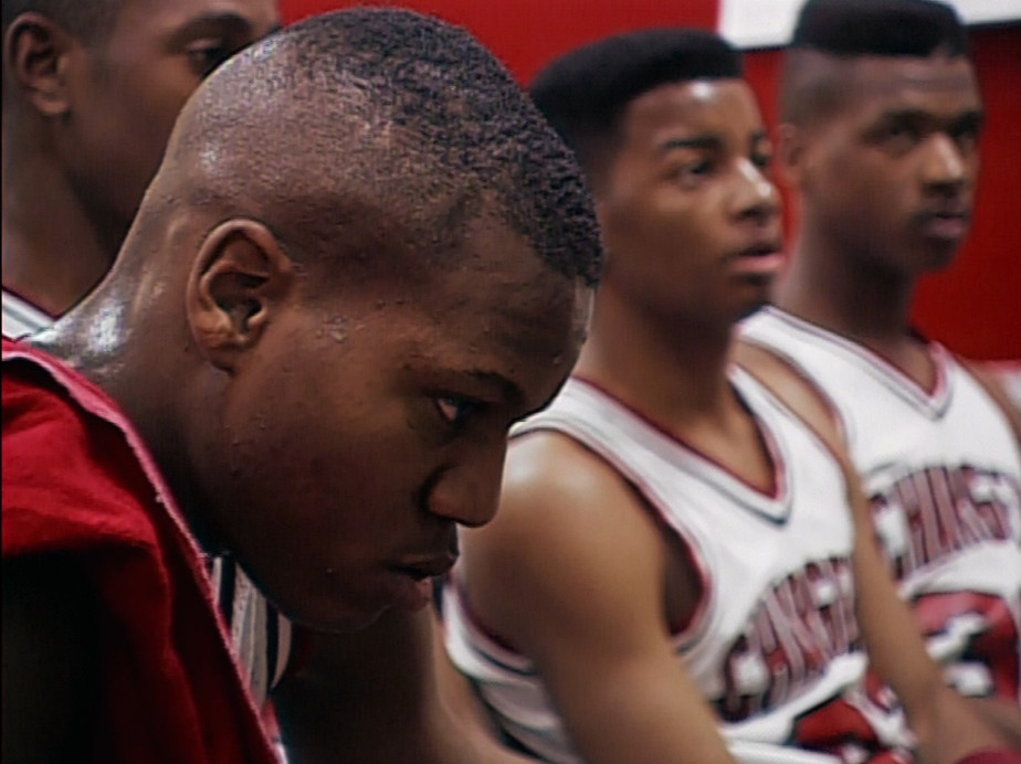 I giocatori di basket di Hoop Dreams pensano e ascoltano il loro allenatore tra una partita e l'altra.