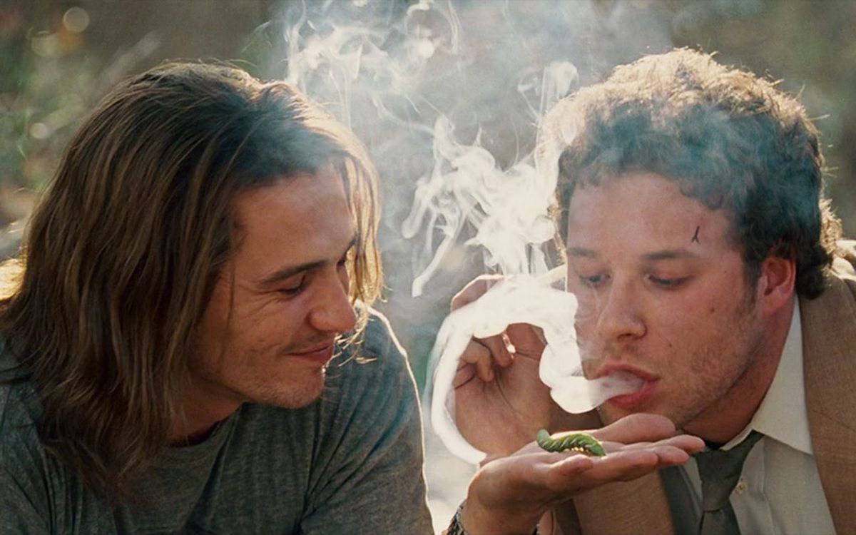 James Franco e Seth Rogen nei panni di Saul Silver e Dale Denton che soffiano fumo d'erba su un bruco in Pineapple Express.