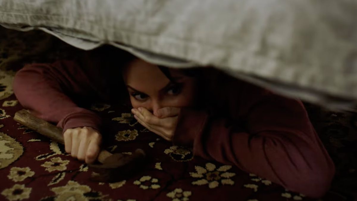 Yulia Klass nei panni di Alys che si nasconde sotto un letto con un martello in mano in Captors.