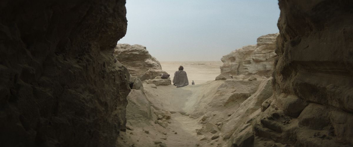 Obi-Wan siede tristemente su una collina di Tatooine con le spalle alla telecamera in Obi-Wan Kenobi. 
