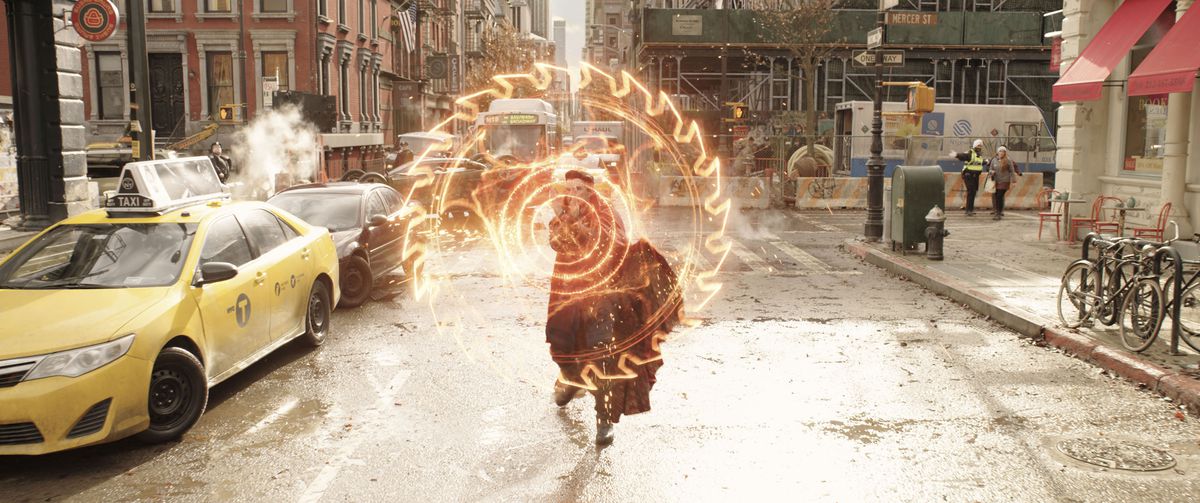 Benedict Cumberbatch nei panni del Dottor Strange, appena visibile dietro una gigantesca lama di sega circolare luminosa che sta ricavando dall'energia in Doctor Strange in the Multiverse of Madness.