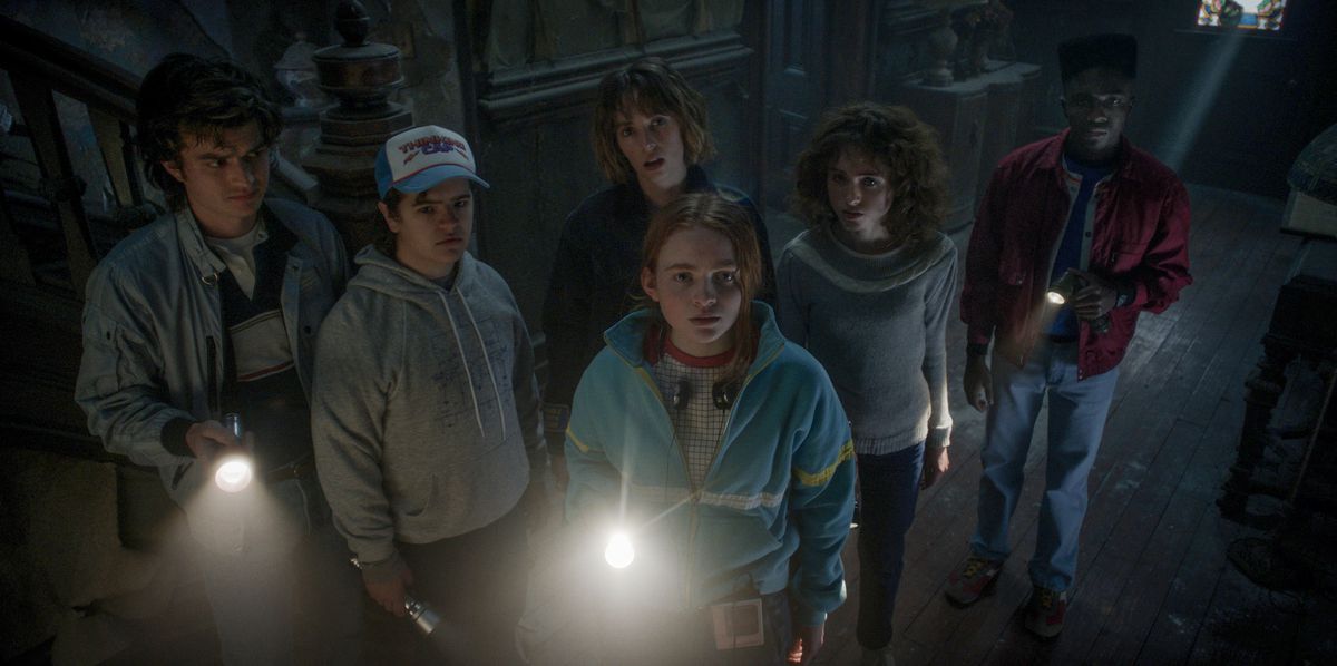 La banda di Hawkins nella stagione 4 di Stranger Things guarda verso la telecamera in una casa infestata